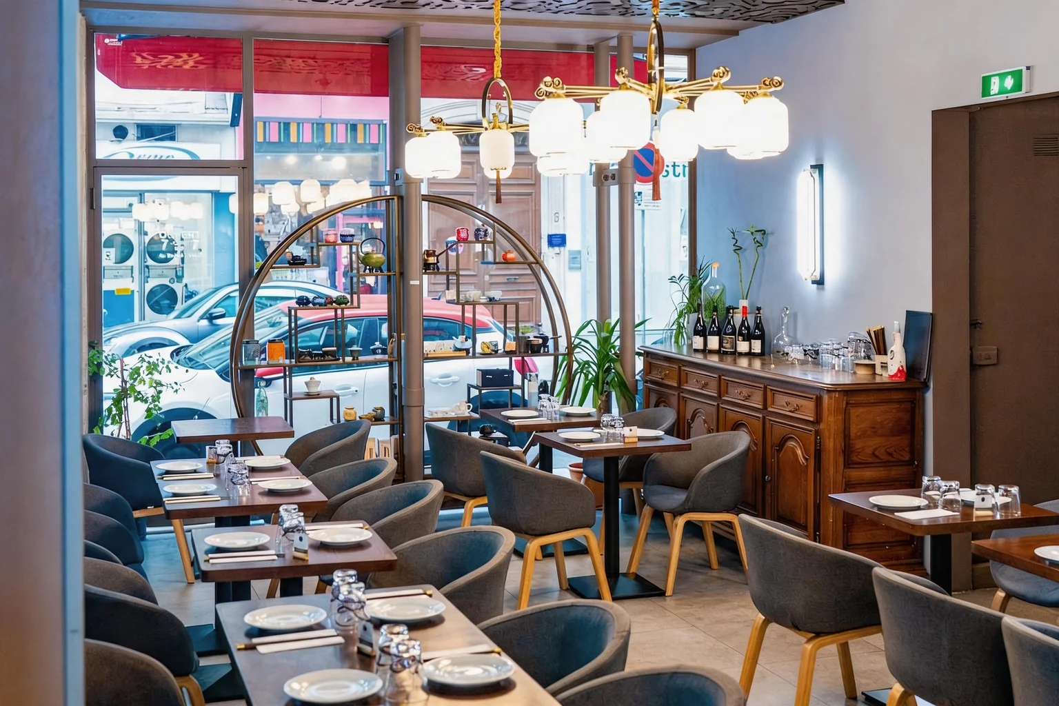The dining room: set tables, chandelier and round shelf in front of the window